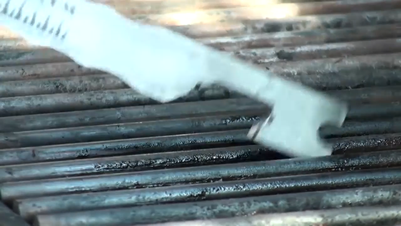 Another close up image of the BBQ Pic cleaning dirty grills of a BBQ.